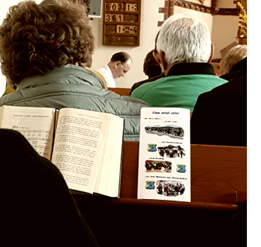 Die Meer Biker nehmen an einem Gottesdienst teil mit aufgeschlagenem Gebetbuch und Meer Biker Flyer auf der Bankablage.