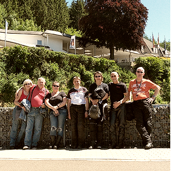 Gruppenbild der Meer Biker Marlene, Schorse, Claudia, Carsten, Angie, Helmut und Bernd vor einer halbhohen Mauer stehend an einem sonnigen Tag