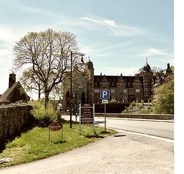 Blick von der Straße auf das Wasserschloss Hämelschenburg in Emmerthal im Weserbergland bei sonnigem Frühlingswetter