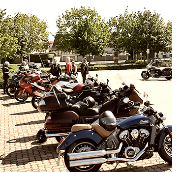 Die Meer Biker und Gäste stehen in einer Gruppe auf einem Parkplatz zur Abfahrt bereit neben ihren in Reihe stehenden Motorräder.